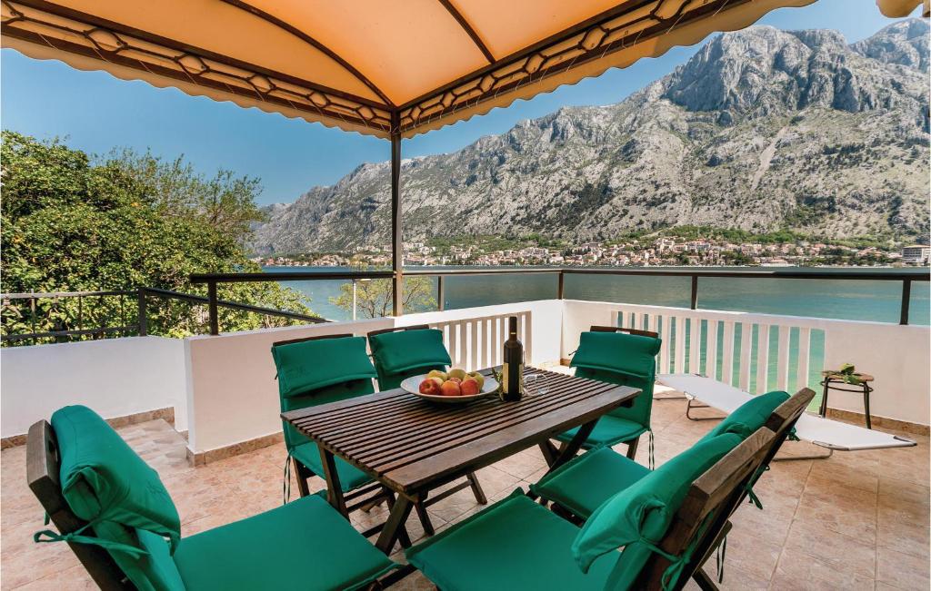 a table and chairs on a balcony with a view of the mountains at Lovely Home In Kotor With Wifi in Kotor