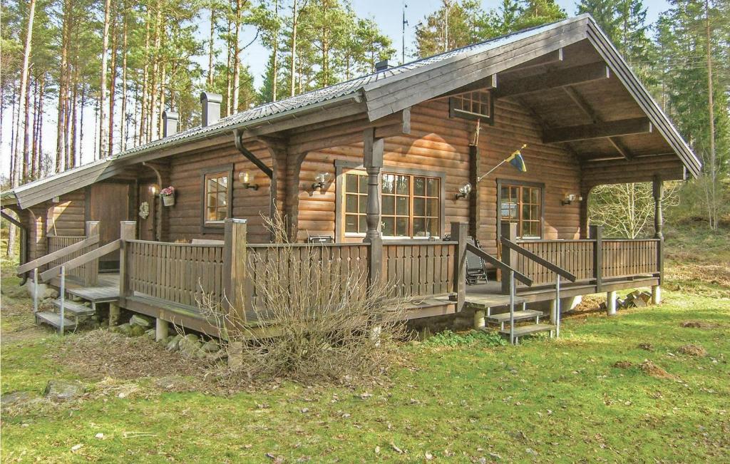Blockhaus mit einer großen Veranda und einer Terrasse in der Unterkunft Amazing Home In Vaggeryd With 3 Bedrooms And Wifi in Ödestugu