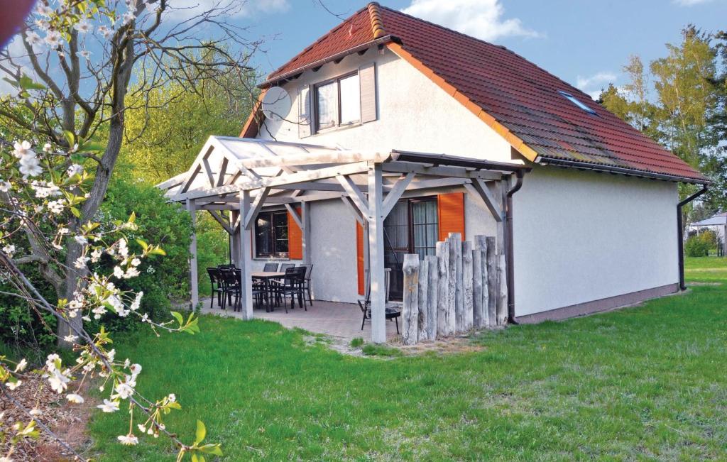ein kleines weißes Haus mit einer Veranda und einem Tisch in der Unterkunft Beautiful Home In Fuhlendorf With 3 Bedrooms And Wifi in Fuhlendorf