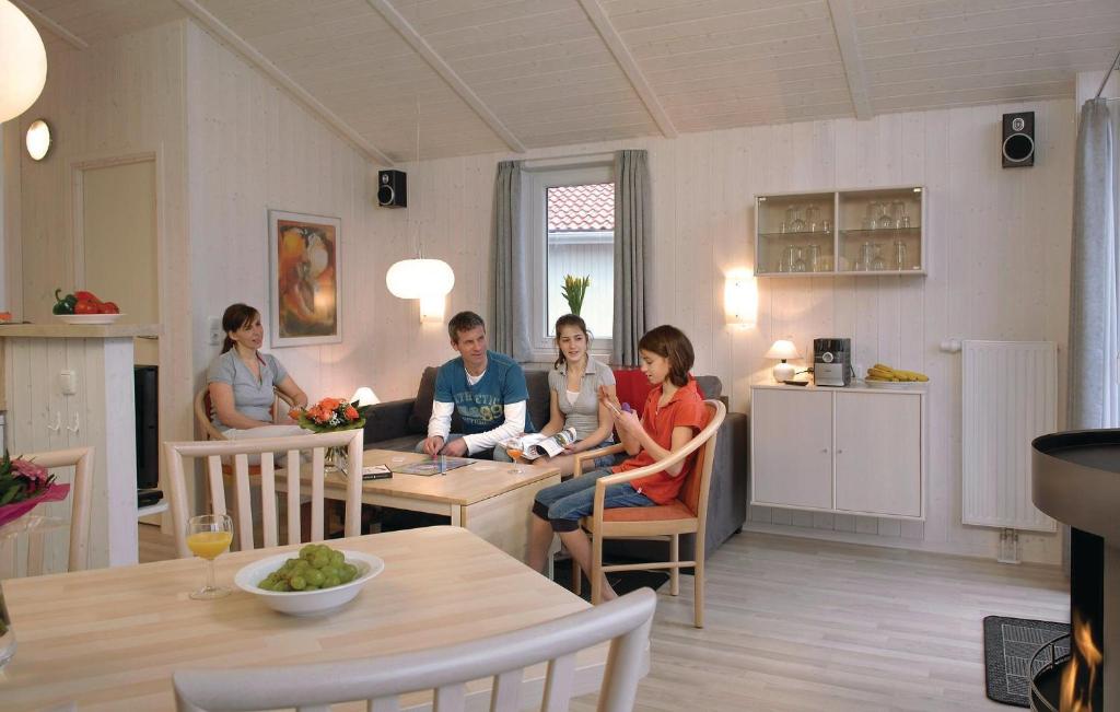 eine Gruppe von Menschen, die an einem Tisch in einer Küche sitzen in der Unterkunft Freibeuterweg 16 - Dorf 5 in Travemünde