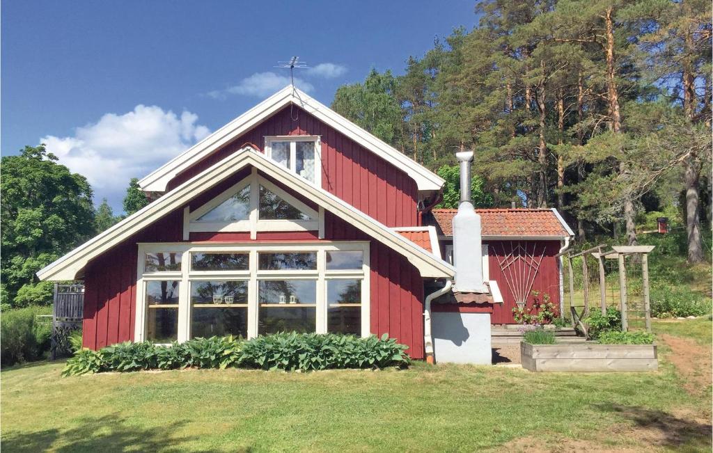 una casa roja con una gran ventana en el patio en 2 Bedroom Stunning Home In Hgster, en Högsäter
