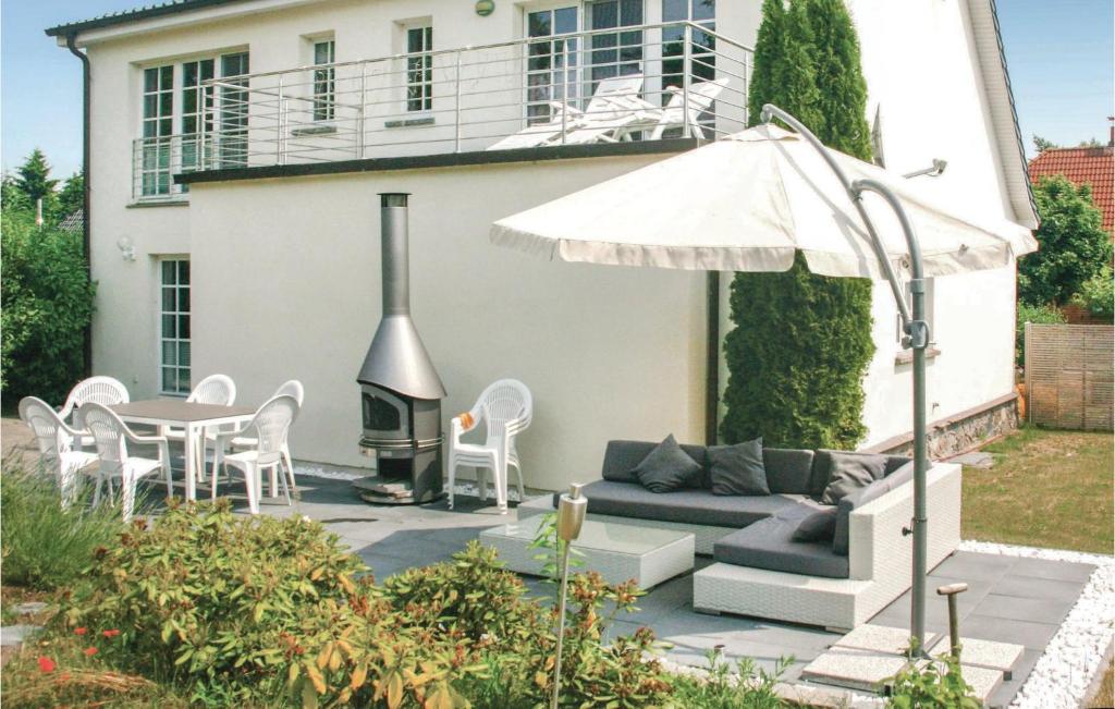 um pátio com um sofá, uma mesa e um guarda-chuva em 3 Bedroom Amazing Home In Beckerwitzhohenkirchen em Hohenkirchen