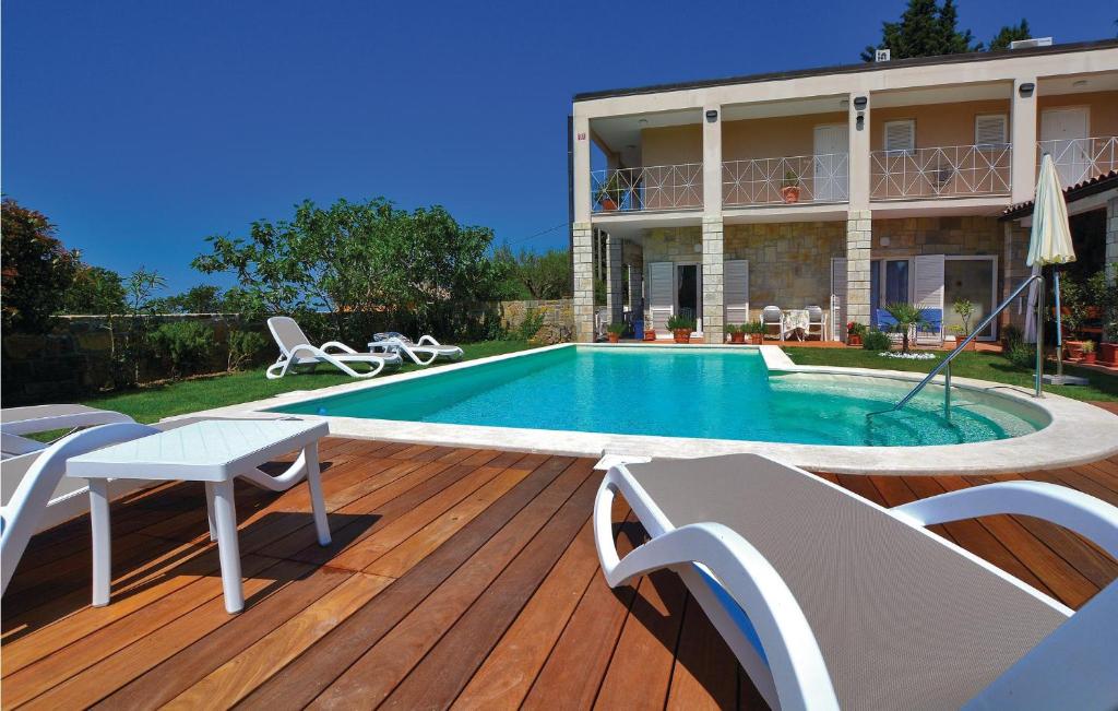 ein Haus mit einem Pool auf einer Holzterrasse in der Unterkunft Gorgeous Apartment In Izola With Kitchen in Izola