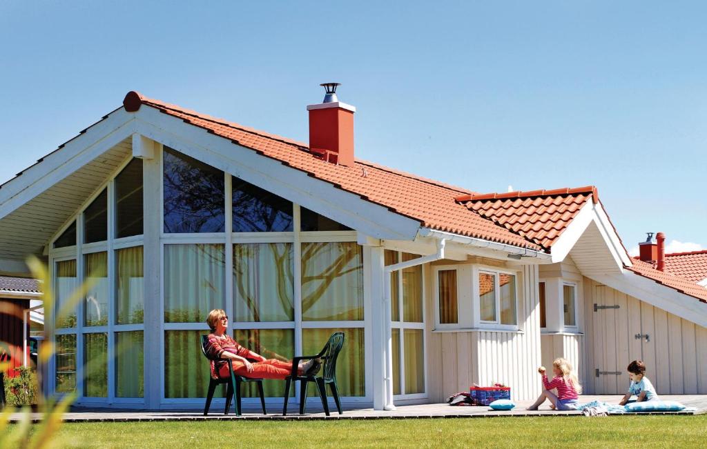 腓特烈斯科格Friedrichskoog-Strandpark 7的坐在房子前椅子上的女人