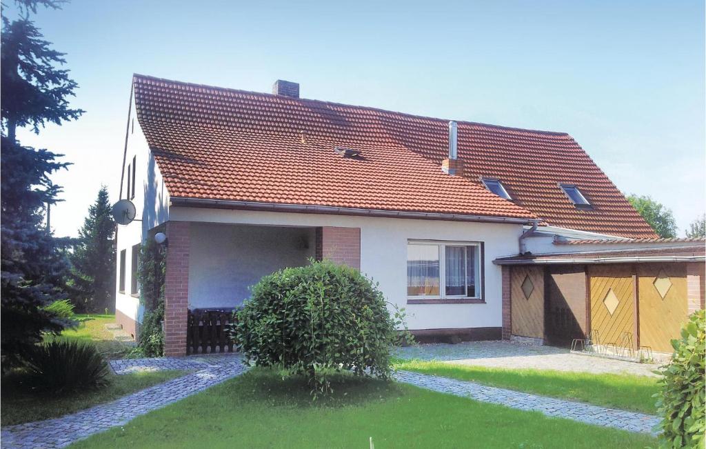 a white house with a red roof at Holiday Home Lübbenaugross Beuchow With Patio 286 in Lübbenau