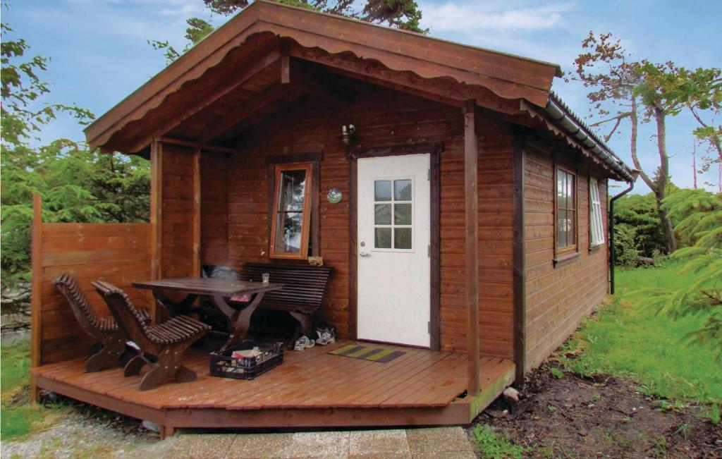 Cabaña de madera pequeña con mesa y sillas en Cozy Home In Kleppe With House Sea View, en Orre