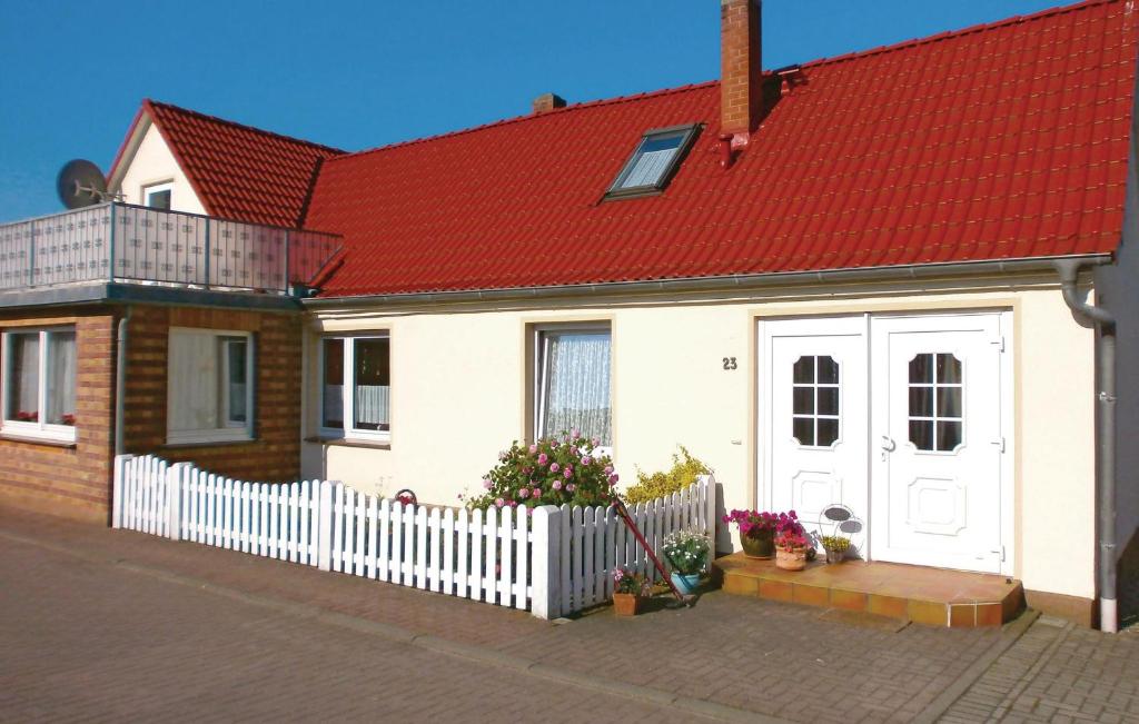 ein weißes Haus mit rotem Dach und einem weißen Zaun in der Unterkunft Awesome Apartment In Elmenhorst-lichtenhag, With Kitchenette in Elmenhorst