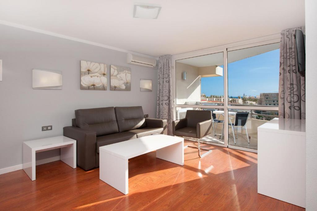 a living room with a couch and a table at Olé Tropical Tenerife Adults Only in Playa de las Americas