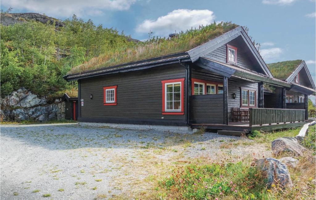 Amazing Home In Hemsedal With Sauna في هيمسيدال: منزل خشبي خلفه تل عشبي