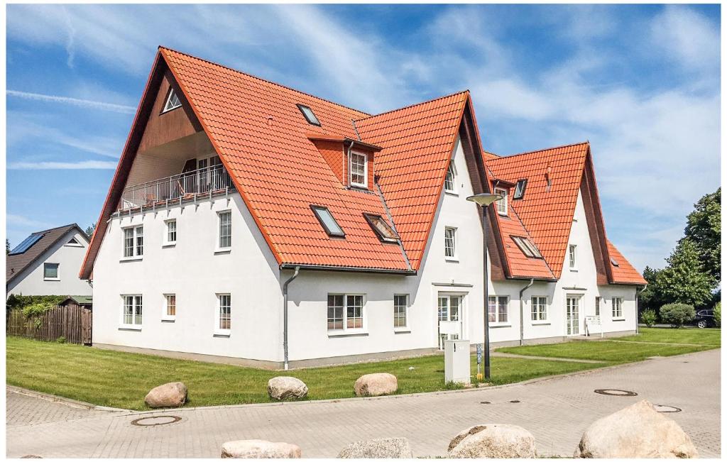 ein großes weißes Haus mit orangefarbenem Dach in der Unterkunft 1 Bedroom Cozy Apartment In Elmenhorst in Elmenhorst