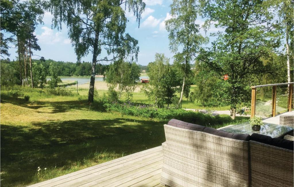 a deck with a view of a field and trees at Lovely Home In Trosa With Kitchen in Trosa