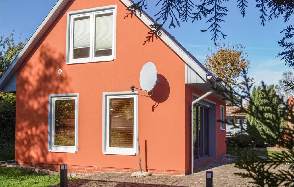 ein rotes Haus mit einem Satelliten in der Unterkunft Ferienhaus Hildebrandshagen V in Woldegk