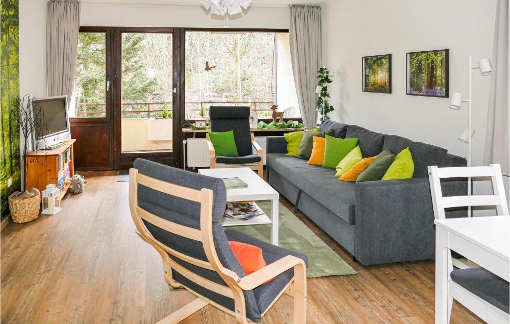 un soggiorno con divano grigio e cuscini colorati di Rehfugium a Bad Sachsa