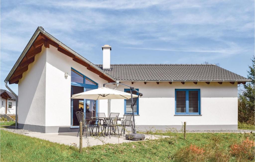 ゲロルシュタインにあるAmazing Home In Gerolstein With Kitchenの小さな白い家(椅子、傘付)