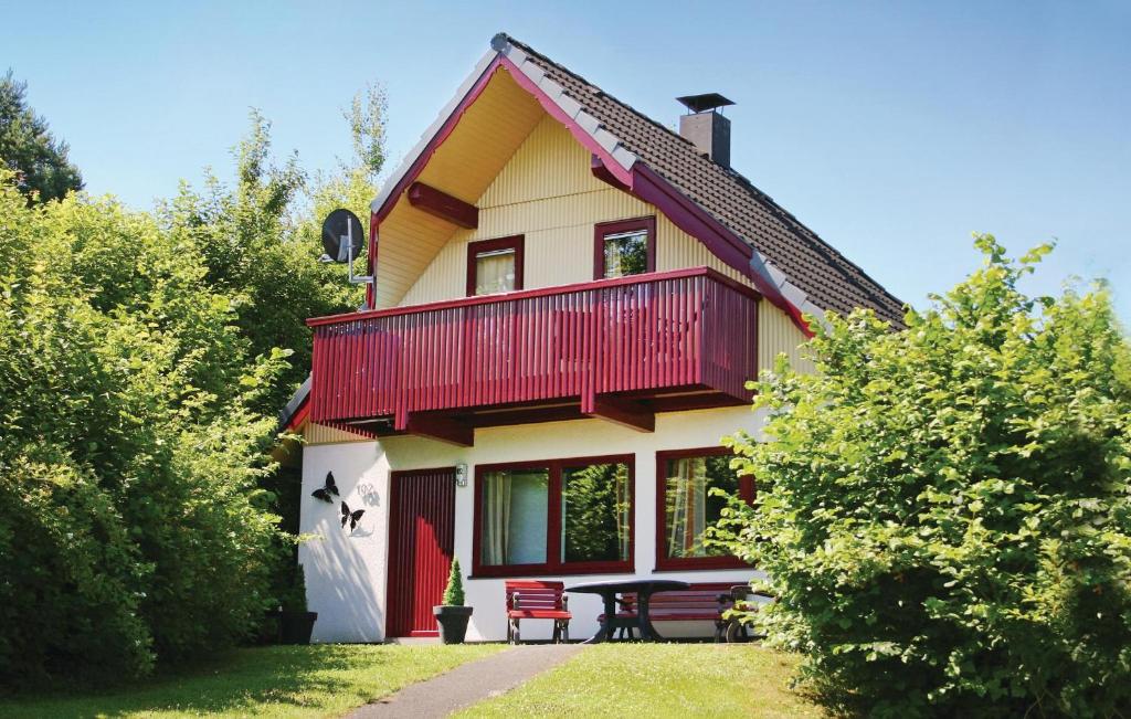 KemmerodeにあるFerienhaus 102 In Kirchheimの赤いバルコニーとテーブル付きの家