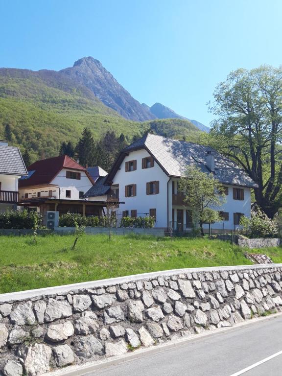 a group of houses and a stone wall next to a road at MMMM in Bovec