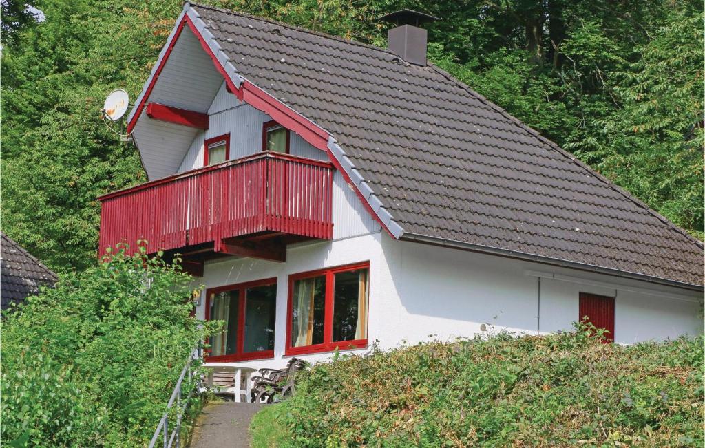 a white house with a red balcony on a hill at Ferienhaus 28 In Kirchheim in Reimboldshausen