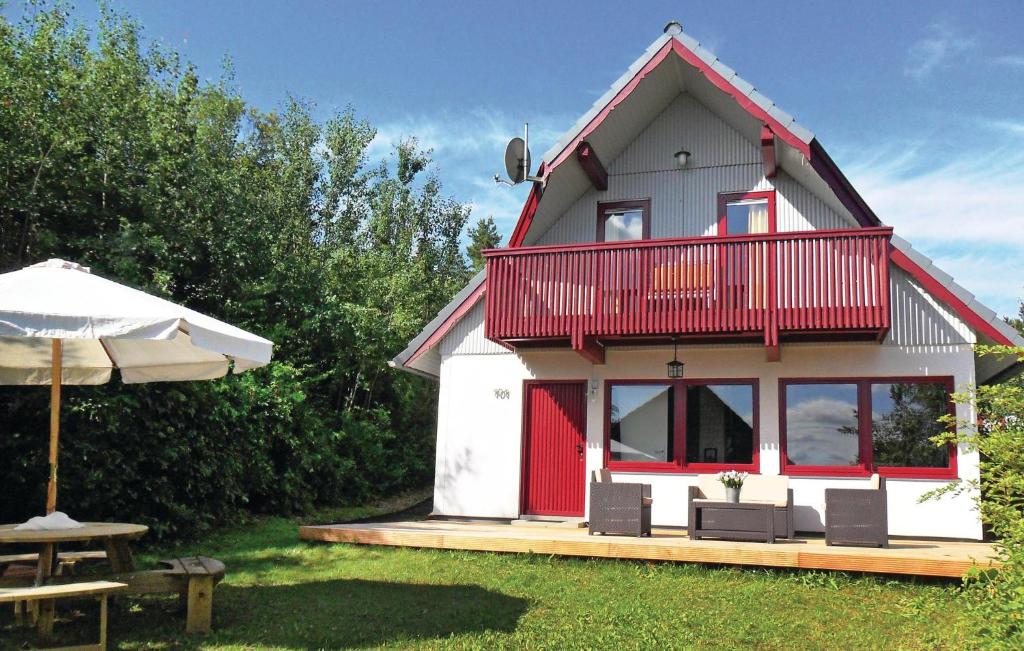 une maison rouge et blanche avec une table et un parasol dans l'établissement Ferienhaus 101 In Kirchheim, à Kemmerode