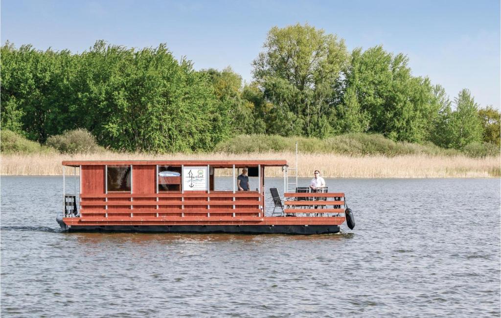 un barco en el agua con una persona en él en Gorgeous Ship In Neustrelitz With House Sea View en Buchholz