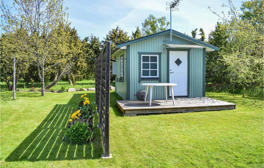 um barracão verde com uma mesa num quintal em Sandvik 2 em Löttorp