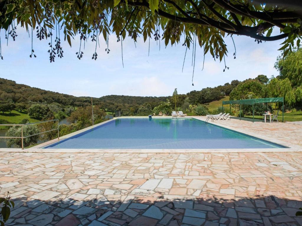 een groot zwembad met een stenen patio bij Country mansion in Montemor o Novo Alentejo with shared pool in Montemor-o-Novo