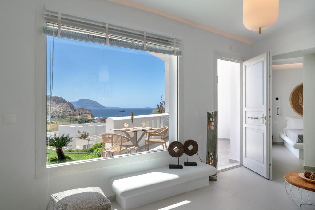 a living room with a large window with a view of the ocean at Arkasa Palace in Arkasa