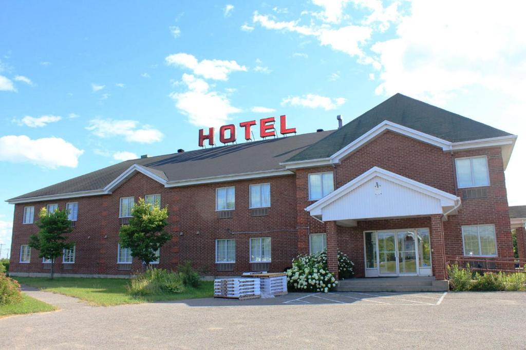 a hotel with a sign on the top of it at Hôtel Le Portneuvois in Portneuf