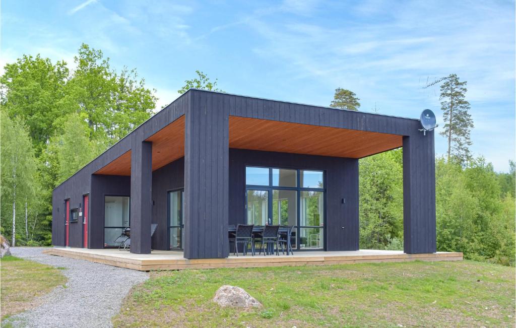 uma casa preta com um telhado de madeira em Beautiful Home In Holmsj With Sauna em Holmsjö
