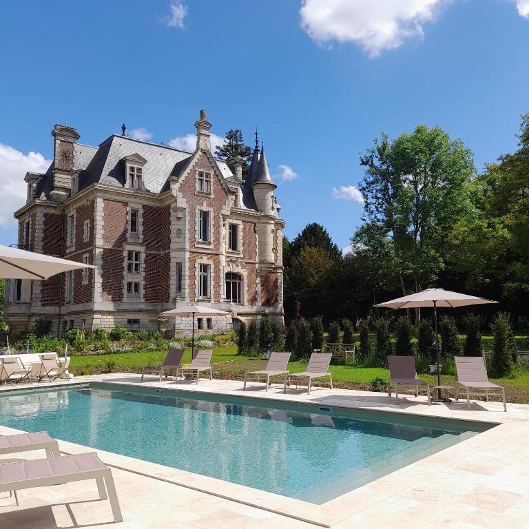 une grande maison avec une piscine devant dans l'établissement Chateau de Hiéville, à Hiéville