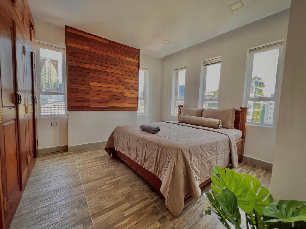 a bedroom with a bed in a room with windows at WH Bassac Residence in Phnom Penh