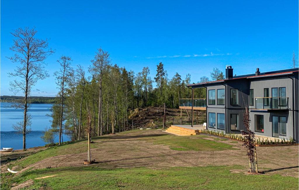 a large house on a hill next to the water at Lovely Home In Skillingaryd With Sauna in Skillingaryd