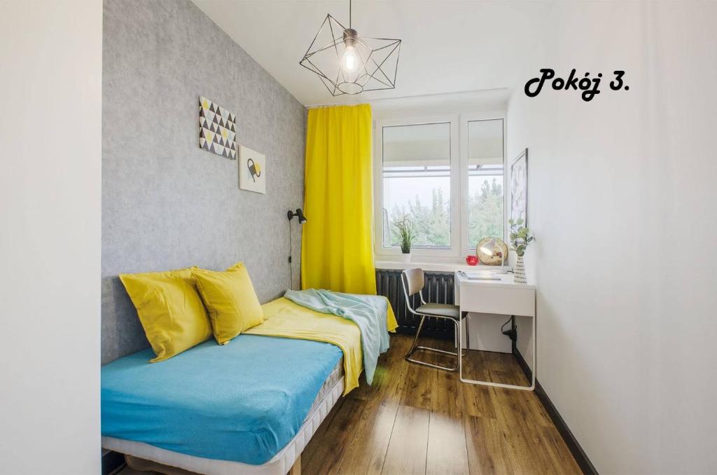 - une petite chambre avec 2 lits et un bureau dans l'établissement Pomorska Rooms, à Łódź