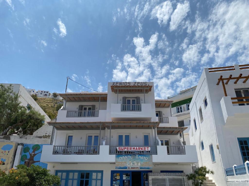 a white building with a sign in front of it at Xenios Zeus Apartments in Astypalaia Town