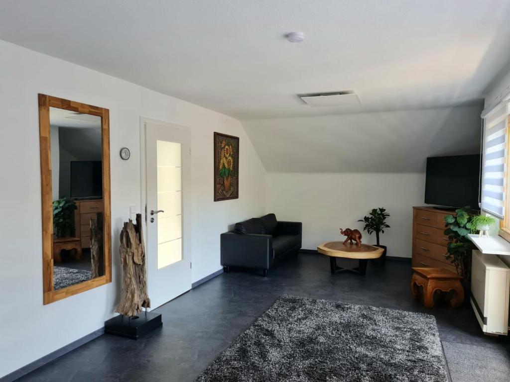 a living room with a black couch and a mirror at Relax 2 in Bad Wildbad