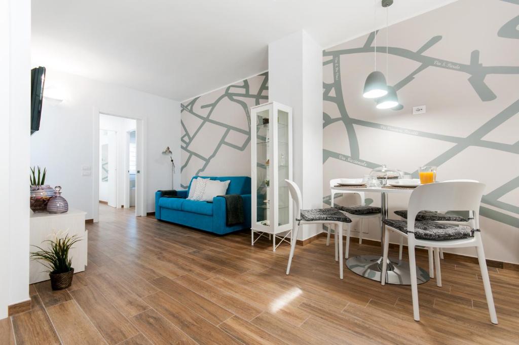 a living room with a table and chairs and a blue couch at Residenza 1955 in Matera