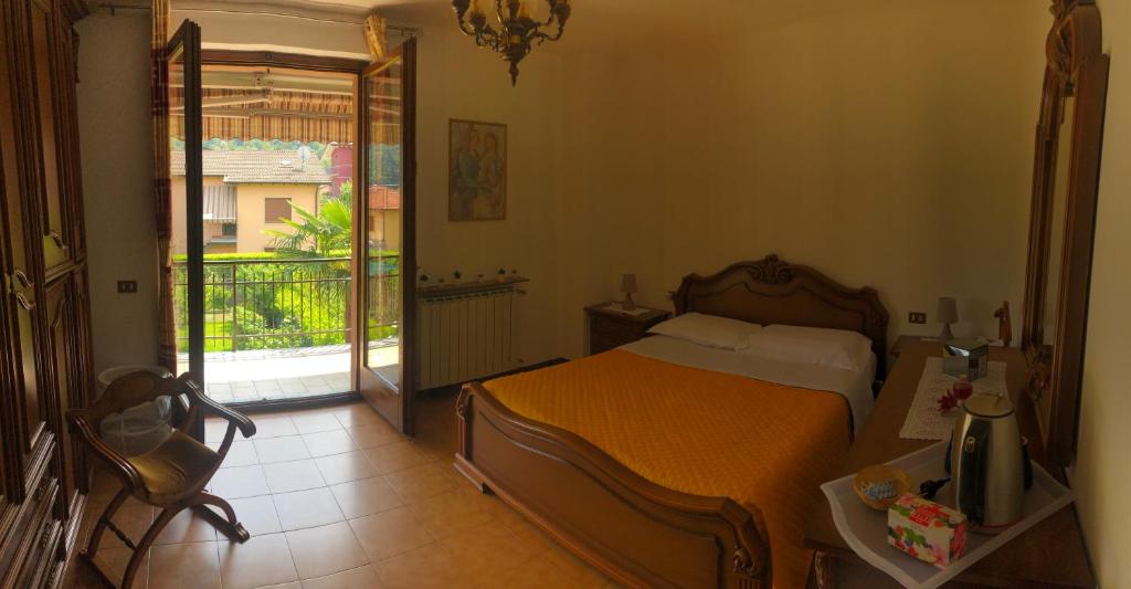 a bedroom with a bed and a balcony at Casa Tiziana in Lavena Ponte Tresa