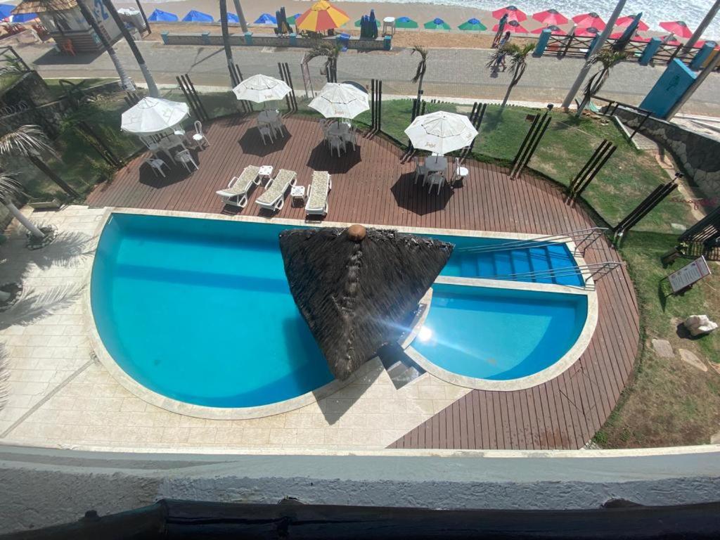 an overhead view of a pool with chairs and umbrellas at Flat Beira Mar- Ap 306 #ELEGANCE in Natal