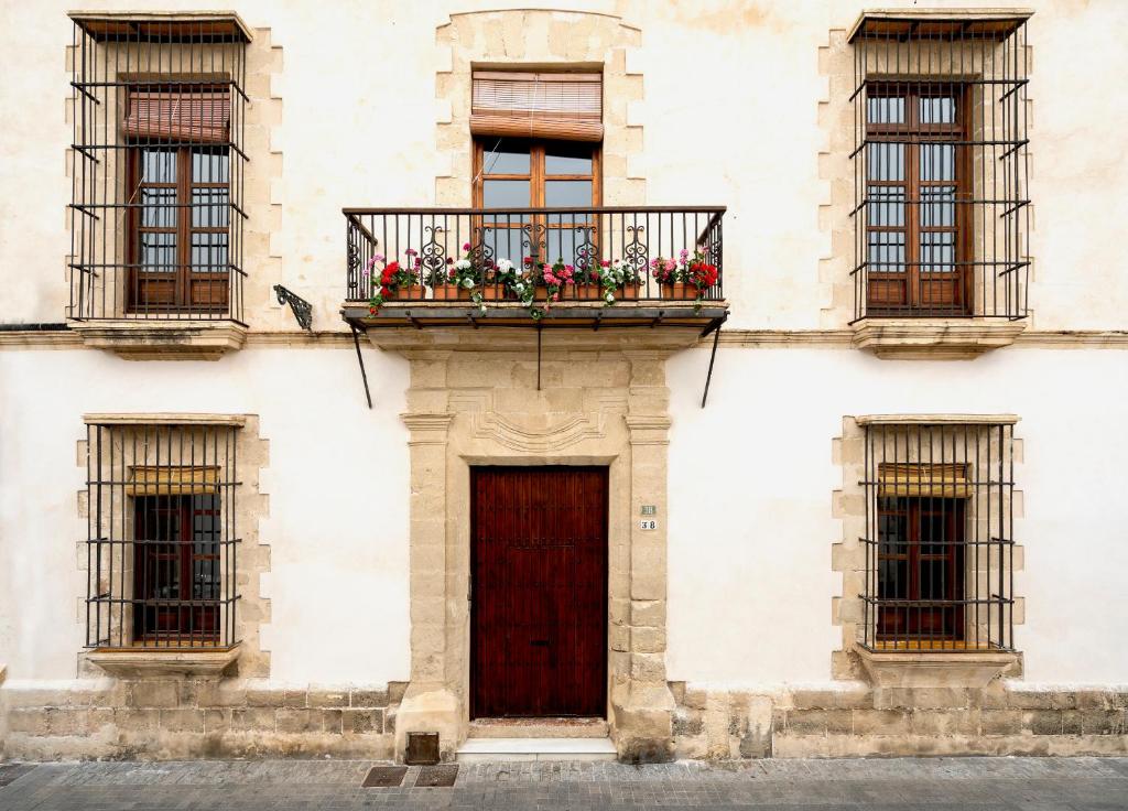 a building with a balcony with flowers on it at CASA PALACIO SUR in El Puerto de Santa María