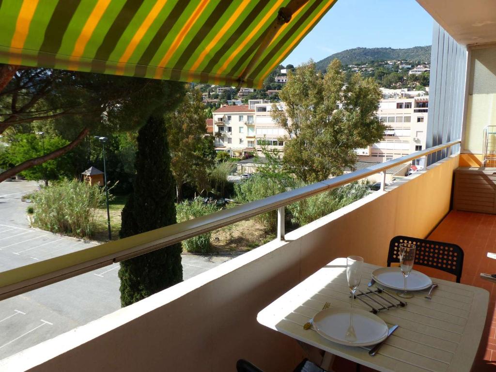 una mesa blanca y sillas en un balcón con vistas en Studio Le Lavandou, 1 pièce, 2 personnes - FR-1-308-110 en Le Lavandou