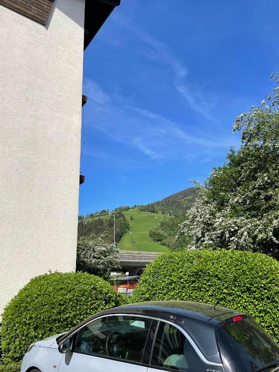 biały samochód zaparkowany przed budynkiem w obiekcie Vidaoro Studio Flat w mieście Zell am See