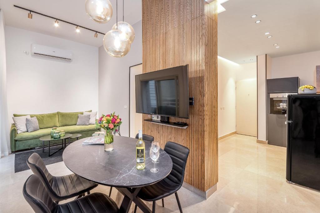 ein Wohnzimmer mit einem Tisch, Stühlen und einem TV in der Unterkunft Sea U Jerusalem Mahane Yehuda Apartment Hotel in Jerusalem