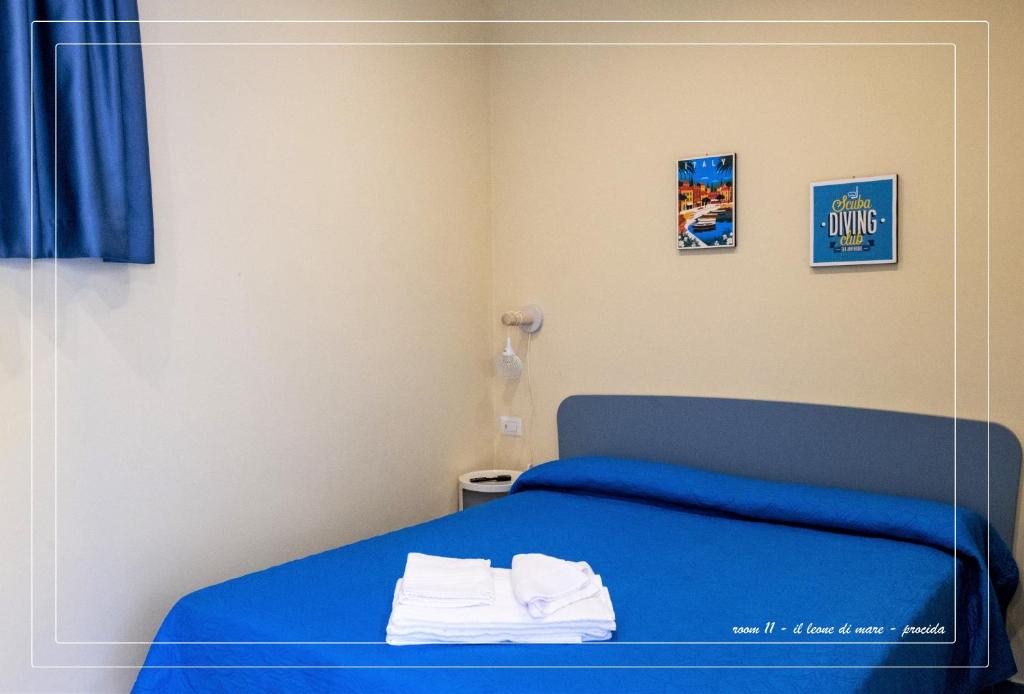 a bedroom with a blue bed with towels on it at Il Leone Di Mare in Procida
