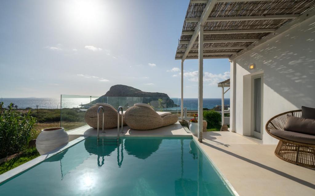 a swimming pool with chairs and a view of the ocean at Arkasa Palace in Arkasa