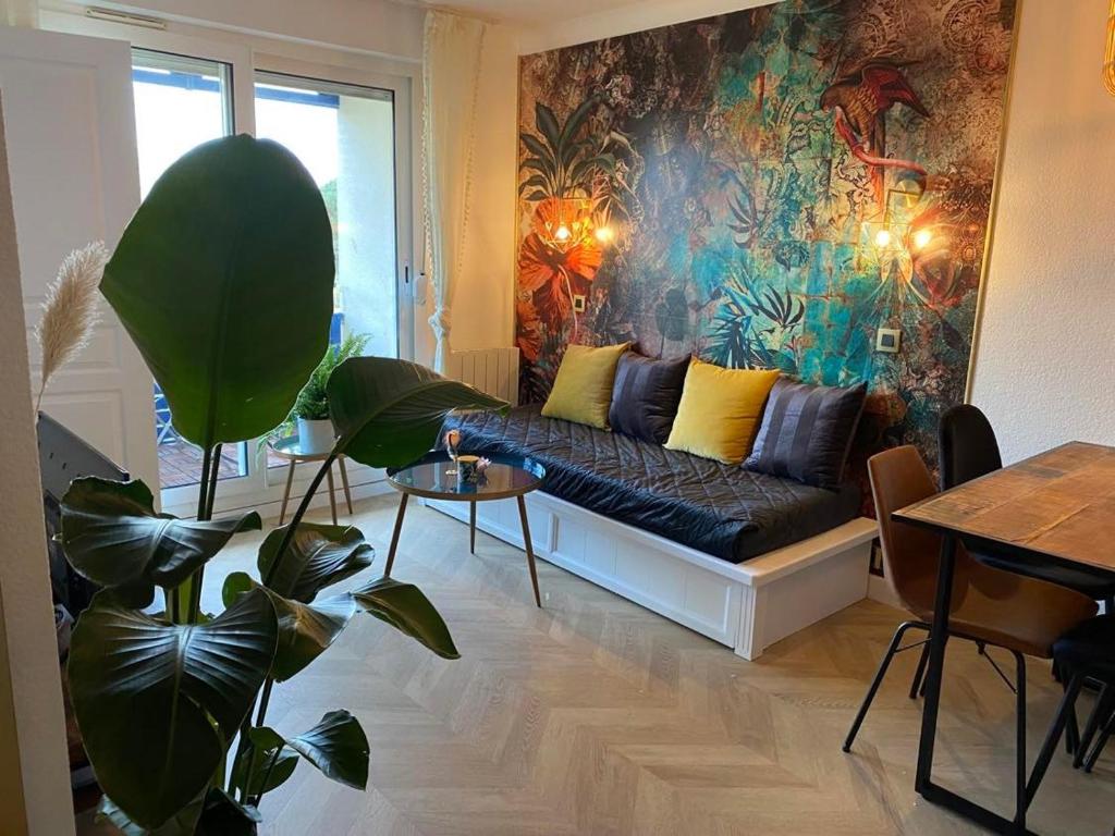 salon z kanapą i obrazem na ścianie w obiekcie Appartement COSY avec piscine, accès direct plage w mieście Lacanau-Océan