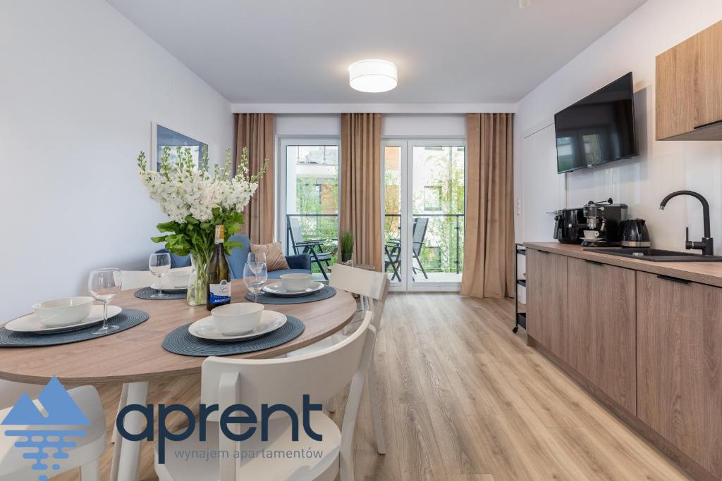 a kitchen and dining room with a table and chairs at Apartament MEWA Pobierowo Baltic Apartments - z krytym basenem - Aprent in Pobierowo