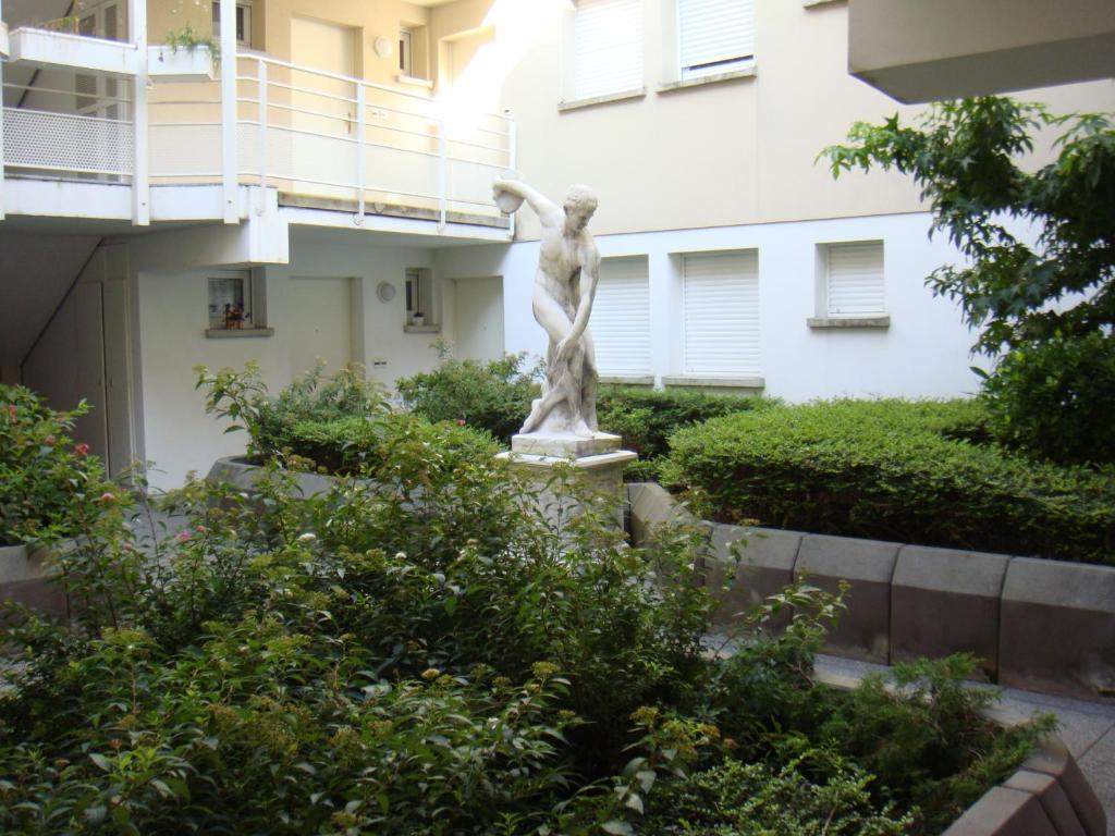 een standbeeld van een vrouw voor een gebouw bij Apollon home Robertsau in Straatsburg