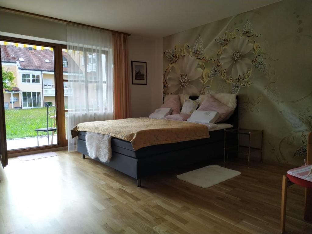 Un dormitorio con una cama con almohadas rosas. en Ferienwohnung Dana en Murnau am Staffelsee