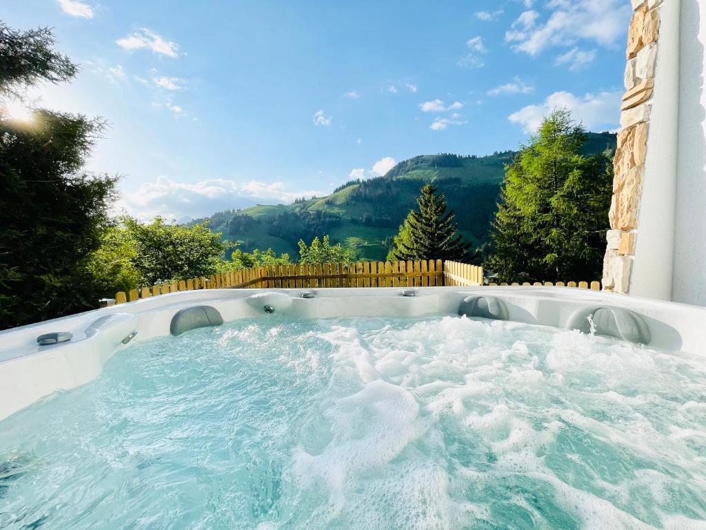 a hot tub in a backyard with mountains in the background at Chalet Edelweiss in Moleson