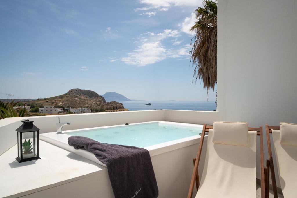 a soaking tub on a balcony with a view of the ocean at Arkasa Palace in Arkasa