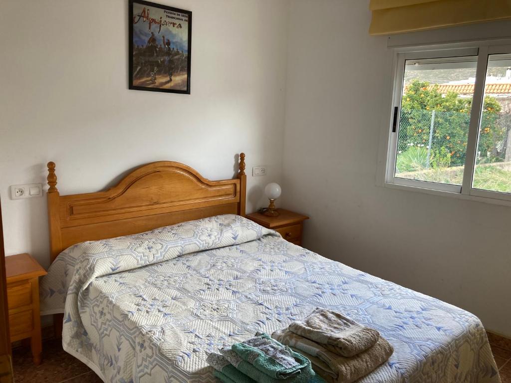 1 dormitorio con 1 cama con 2 toallas en La casa de Paco el Ventero El Secadero, en Almócita